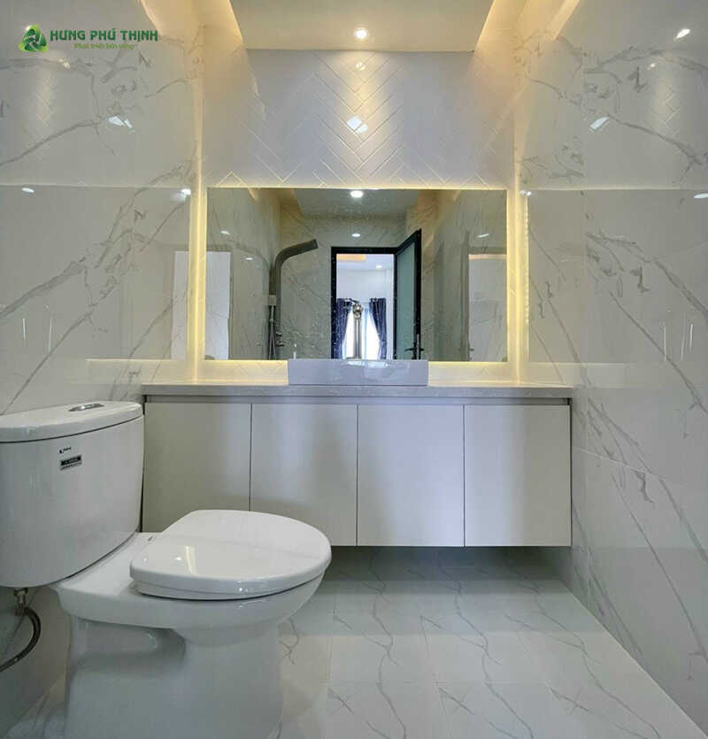 Nhà vệ sinh có thiết kế sáng sủa và sạch sẽ với tone màu trắng kem chủ đạo